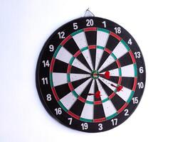 Three red dart hitting bullseye on dartboard isolated on white background. Perfect target accuracy, success, focus, business strategy, goal achievement, competition and leadership concept. photo