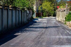 A road with a white sign that says yield on it. The road is empty and there are no cars or people on it photo