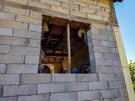 A window in a building with a brick wall. The window is open and has a lot of debris in it photo