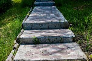 A concrete walkway with steps leading up to it. The steps are made of concrete and are covered in grass photo