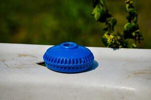 A blue object sits on a white surface. The object is round and has a hole in the middle photo