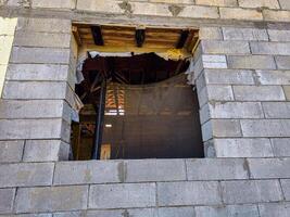 A window with a mesh screen in front of it. The mesh screen is black and white. The window is in a building made of bricks photo