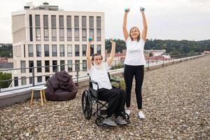 Senior woman and man, one in wheelchair, exercising together outdoors using dumbbells, showcasing fitness and support. photo
