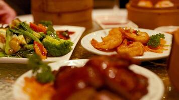 A vibrant display of dimsum and deep-fried shrimp in a warm, inviting restaurant setting with rich lighting video