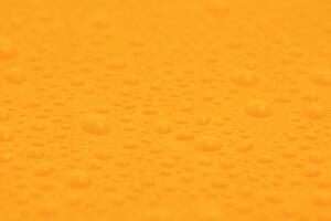 Yellow plastic background with many water drops. photo