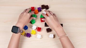 Hands organizing colorful cubes on a table video