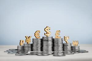 Stack of coins in rows with gold international currency symbols, Yen, Euro, Dollar, Pound, Rupee and Won. Concept of financial, monetary value, currency exchange rates and investments around the world photo