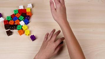 Hands organize colorful cubes on a table video