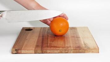 Sequential demonstration of slicing an orange on a board video