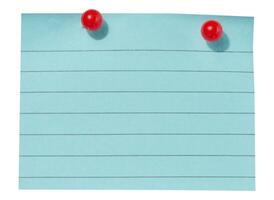 A sheet of blue lined paper attached with two red pushpins on an isolated background photo