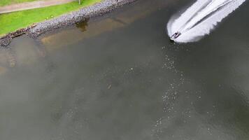 A speedboat navigates the Gold Coast canals, creating dynamic water trails. Overhead view captures lush greenery and calm waters video