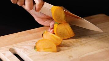Hands slicing persimmon with sharp knife video