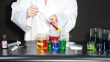 Scientist conducting experiment with colorful liquid video