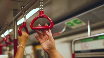 Hands gripping handles in Hong Kong subway video