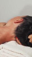 Mature woman blissfully enjoying a soothing head massage in a tranquil spa setting video
