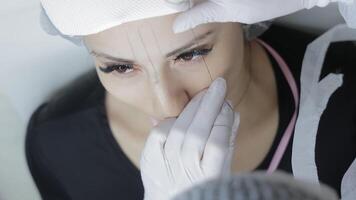 Cosmetic Procedure Preparation Scene, Beautician Drawing Guidelines on Woman's Face with Thread video