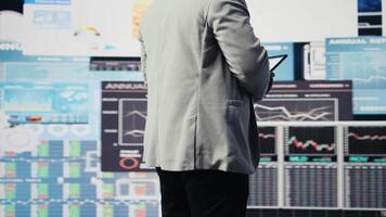 Black male entrepreneur reviews financial graphs and KPI models, reviewing business performance reports with strategic insight for fintech materials and forecasting tools. Management. Camera A. video
