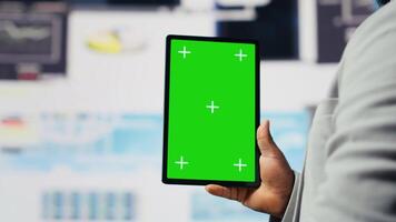 Entrepreneur looks at tablet with chroma key for analysis, reviewing monthly reports and infographics for company development. Good performance metrics for growth, forecasting. Camera B. video