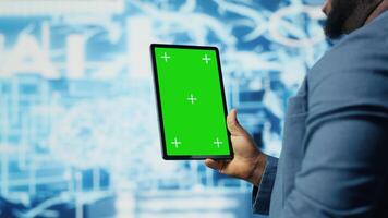 African american expert holds tablet with isolated screen next to cloud computing systems, focused on AI brain development and machine learning for innovation. Smart tech data science. Camera B. video