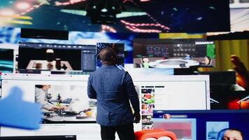 African american expert exploring tech driven environment with visual data, content feeds and applications. Symbolizing entertainment, social reach and digital transformation. Camera A. video
