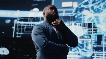 schwarz männlich Spezialist beschäftigt, verlobt im ai Forschung interagieren mit Daten Strukturen oder Plattformen und Clever Technologie Systeme. Studien tief Lernen, Wolke Computing und vorausschauend Analytik. Kamera b. video