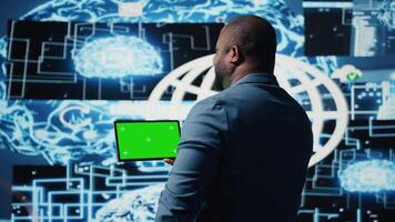 noir il spécialiste examiner algorithmique Les données suivant à chrominance clé, en utilisant tablette dans une haute technologie environnement avec futuriste numérique visuels. ai intelligent La technologie et neural réseaux. caméra un. video