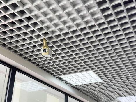 Surveillance camera on the lattice ceiling. Modern technologies photo