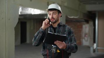 Man builder foreman engineer talking mobile phone on construction site problem building industry stressed angry guy male Caucasian handyman architect repairman inspector call cellphone arguing trouble video