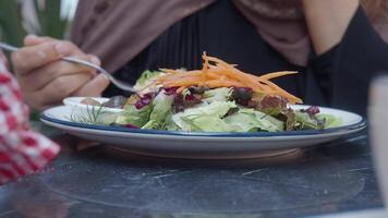 Enjoying a fresh salad at an outdoor cafe setting video