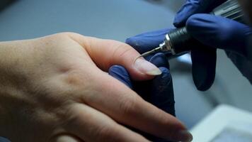Manicurist does the processing of the cuticle to a special apparatus cleaning nails using manicure cutter. macro. close-up removing gel, manicure machine, Female master. Nail technician cleans nails video