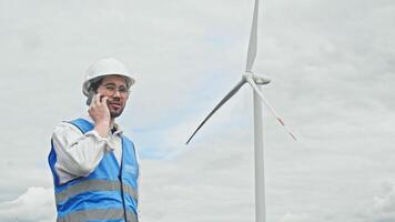 Inspector calls process engineer about breakdown of wind turbine, which has stopped rotating and no longer generates energy. He is actively gesturing and swearing with displeasure. video