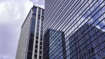 A timelapse of moving cloud reflecting the building at the city low angle view panning video