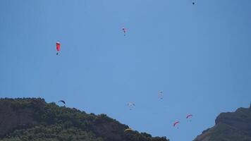 Paragliding, Mountain, Sky - Paragliders soaring through the sky above a mountainous landscape. video