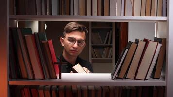 Priest reading holy book in the library surrounded by bookshelves video