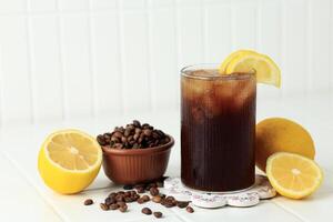 Coffee with Tonic in a Tall Glass with Ice and Lemon on White Table Background. T photo