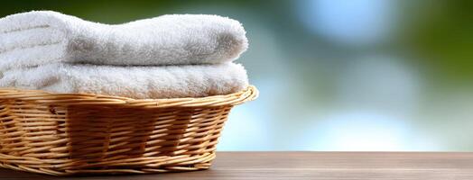 White towels in basket on wooden table photo