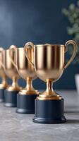Five gold trophies on a table photo