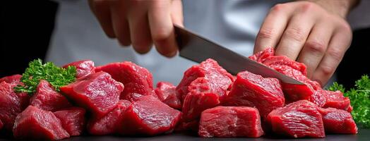 A chef is cutting up some raw meat photo