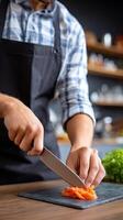 A man in an apron is cutting carrots on a cutting board photo