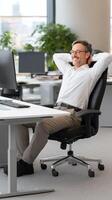 A man sitting in an office chair with his arms up photo