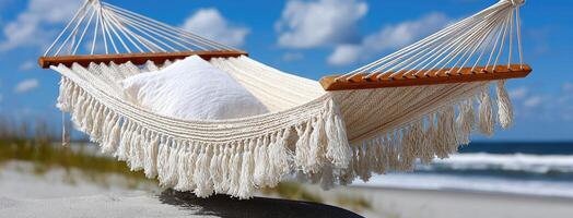 Relaxing hammock on a sunny beach with the ocean in the background, perfect for a tranquil getaway and leisurely moments outdoors photo