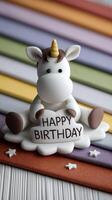 A white unicorn figurine sitting on a rainbow background photo