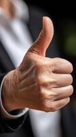 A close up of a business person's thumb up photo