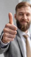 A man with a beard and suit giving the thumbs up photo