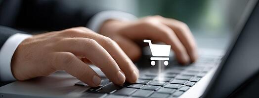 A person in a suit is typing on a laptop with a shopping cart icon photo