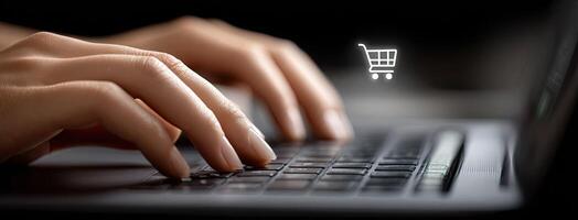 A person typing on a laptop with a shopping cart icon photo