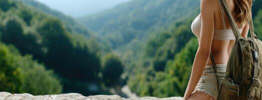 A woman with a backpack sitting on a rock photo