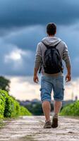 A man with a backpack walking down a path photo