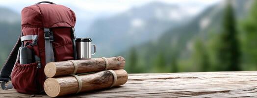 A backpack and a cup sit on a log photo