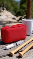 A red bag with a cup and two sticks photo